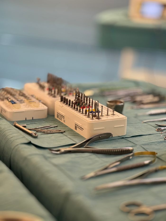 Surgical tools and dental instruments organized on a sterile table in an operating room.